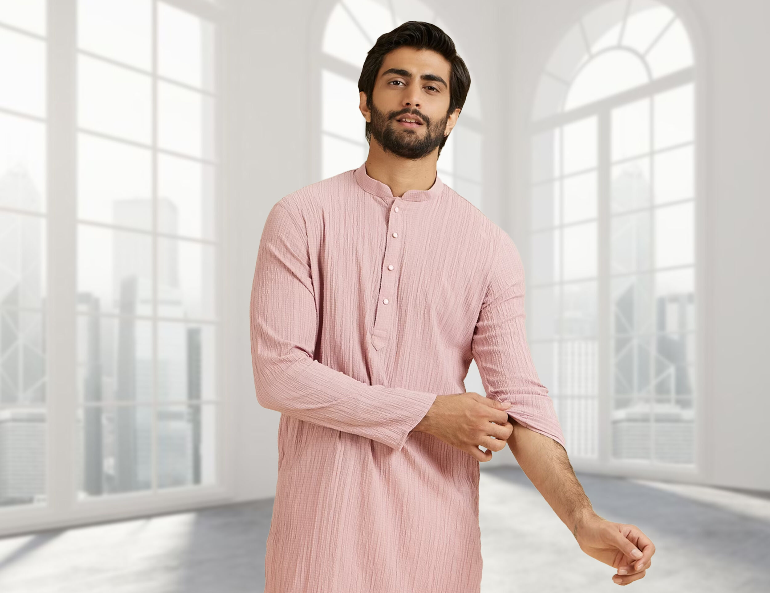 tylish man modeling a peach kurta and adjusting his sleeve